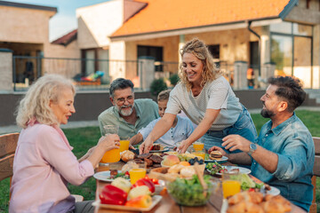 Plakat Happy family enjoying backyard barbecue, serving food and beverages on sunny day