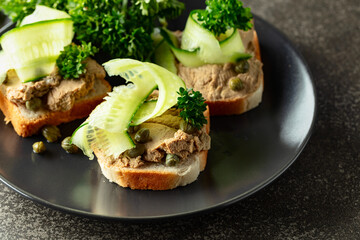 Open sandwiches with pate, fresh cucumber, capers, and parsley.