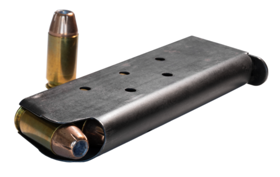 1911 semi-auto pistol magazine loaded with ammunition and a single round outside