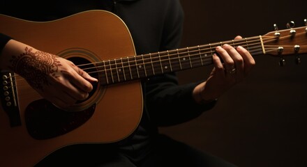 Close-up of Acoustic Guitar Being Played by a Person with Henna Tattoo Expressing Creativity Harmony and Musical Passion in a Dark Studio Setting