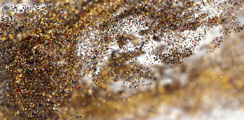 Shimmering gold glitter particles burst. Ideal for holiday, celebration, luxury designs.