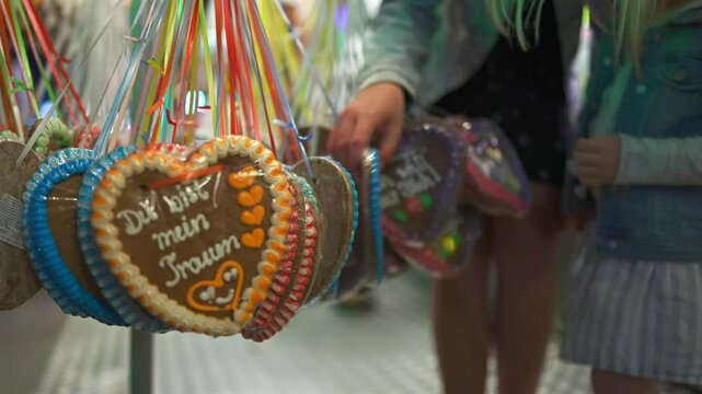 Munich, Germany. Selling souvenirs and sweets at stall at Oktoberfest beer festival in evening with lighting and illumination. Gingerbread merchandise at Oktoberfest in Deutschland. 
