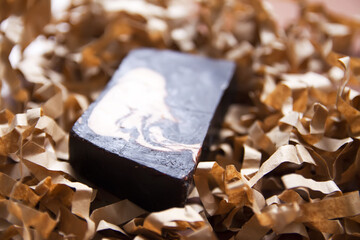 Natural organic soap bar on paper shavings background.
