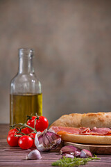 Garlic cloves, cherry tomatoes, and olive oil to make a Serrano ham sandwich