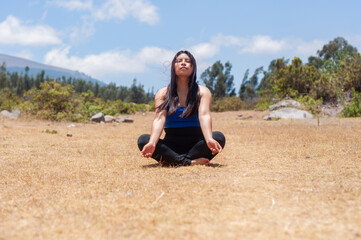 Young woman practicing yoga and meditation outdoors in nature