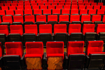 Fototapeta premium Rows of red seats in an auditorium or cinema hall. Evokes entertainment, leisure, and culture.
