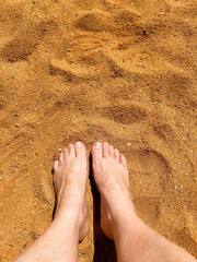 feet in the sand on a sunny day
