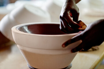 Pottery, bowl and hands of person in studio, workshop or art process for handmade design. Craft, hobby and artist with manufacturing, unique artwork and creative ceramic at sustainable small business