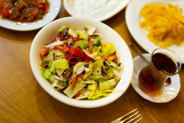 Turkish starter, salad made of lettuce and tomatoes, served on plate in restaurant.