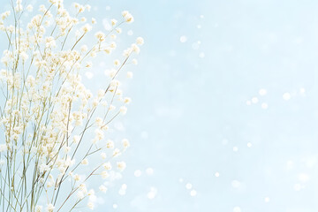 Frame with spring white tiny flowers on blue bokeh background with copy space. Floral border with buds on twigs. Botanical banner with copy space. Wedding spring, botanic, nature event border concept