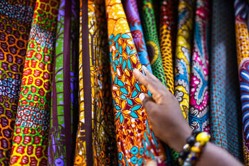 Small business owner of an African Print, Ankara fabric shop proudly displaying different kinds of textile prints.