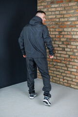 A stylish athlete is depicted in trendy urban sportswear, featuring a fashionable hooded jacket...