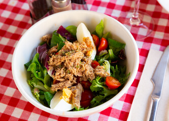 Healthy salad with canned tuna, eggs, vegetables and greens