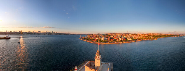 Naklejka premium Kiz Kulesi Panoramic view of Istanbul's skyline and the Maiden's Tower. An aerial panoramic shot of the Istanbul skyline, showcasing the Maiden Tower and the surrounding cityscape. Sunset sunrise tour