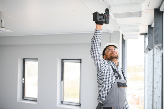 hvac services - indian worker install ducted pipe system for ventilation and air conditioning in house