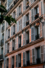 Detailed Classic Parisian Building Facade with Rows of Windows, Shutters, and Balconies 