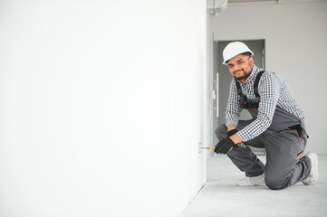 Indian worker makes repairs in an apartment