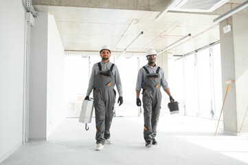 multicultural builders in hardhats at construction site