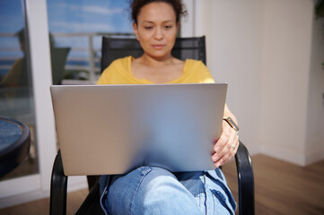 Woman Relaxing with Laptop Indoors in a Bright Room Setting