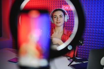Famous blogger. Cheerful female vlogger is showing cosmetics products while recording video and...