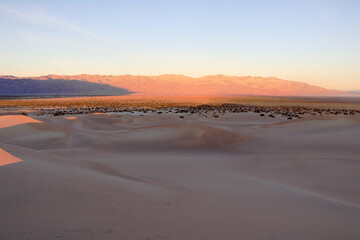 The first rays of the rising sun shine on the Sand Dunes and the distant Cottonwood Mountain range on this December morning