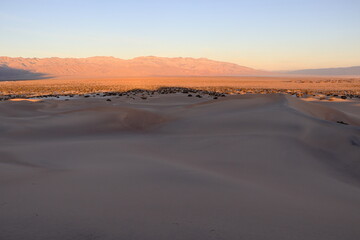 The morning sunlight hits the distant Panamint Mountains as seen from the Mesquite Flat Sand Dunes