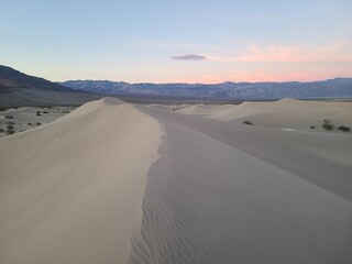 The light of dawn illuminates the dunes at Mesquite Flat Sand Dunes in Death Valley, California