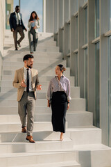 Business people walking and talking on stairs in modern office building