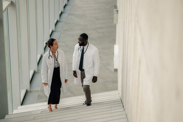 Doctors walking down hospital stairs discussing patient care