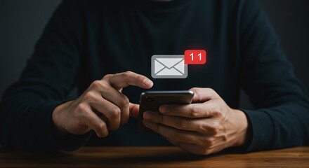 A person using a smartphone with an email notification showing eleven unread messages on the screen
