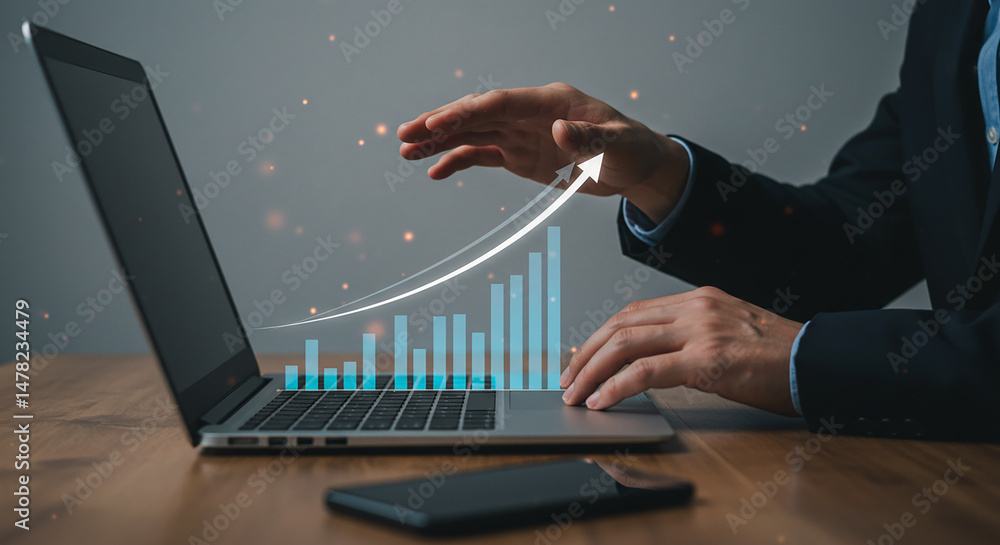 Aufkleber a person analyzing a rising bar graph on a laptop with a phone on the desk in front of them