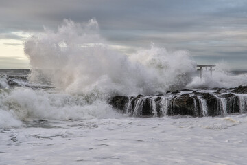 荒れる海と日の出直後の神磯の鳥居
