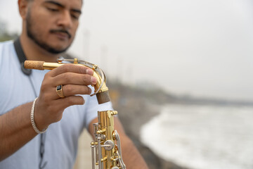 Musician preparing saxophone on beach seeking inspiration