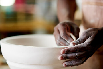 Hands, pottery and person with sandpaper for craft, ceramics and art with handmade pot in workshop. Skill, creativity and closeup for smooth texture, artisan and production process for sculpting