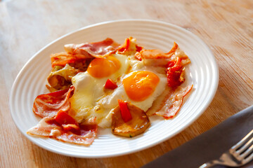 Delicious breakfast - scrambled eggs with bacon and french fries