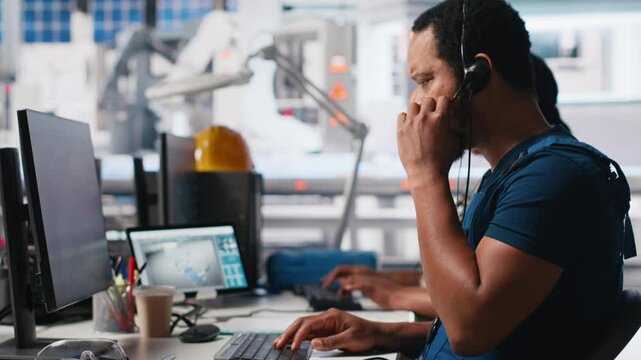 Call center technician handling maintenance inquiries in solar factory, working in customer service industrial tech support. African american operator on headset with clients. Camera A.