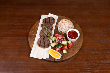 Istanbul lefte, Turkish rice with meat and adjika, mixed salad and shish kebab made from local minced meat on the table in the restaurant on a wooden stand