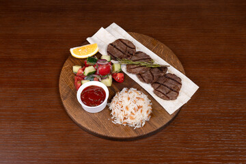 Istanbul lefte, Turkish rice with meat and adjika, mixed salad and shish kebab made from local minced meat on the table in the restaurant on a wooden stand