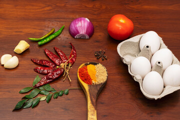 Closeup Image Of Indian Cooking Ingredients. Kerala Spices, Eggs, Tomato, and Curry Leaves on Wooden Background