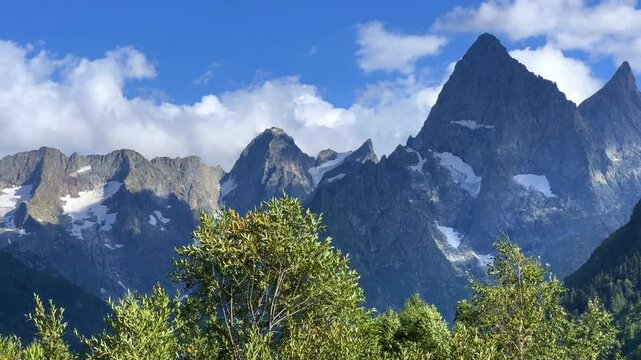 Teberdinsky Nature Reserve. View of Kosygin's glade in the Gonachkhir gorge and the top of Dombai-Ulgen mountain near Lake Tumanly-Kel on a sunny summer day. Panoramic landscape. Resort. 4K
