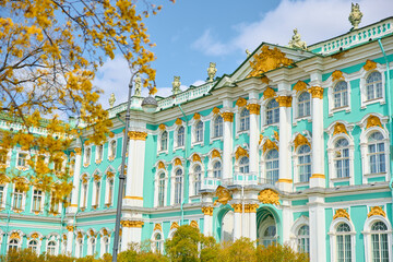 the incredibly picturesque facade of the Winter Palace through the branches of trees on a clear...