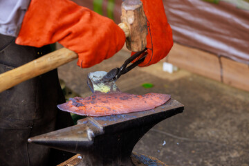 Craftsman expertly hammering heated metal on an anvil while showcasing traditional blacksmithing...