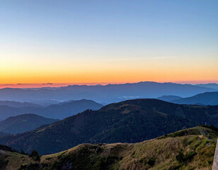 Obraz premium Majestic mountain ranges at sunset, painted in hues of orange and pink, create breathtaking panoramic view