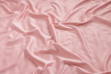 Obraz premium Beautiful pink silk linens on bed, above view