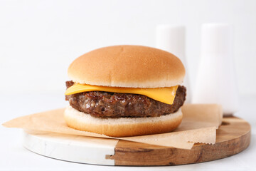 Cheeseburger with tasty patty on white table, closeup