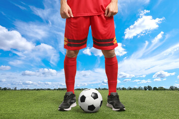 Football player with soccer ball under blue sky, closeup