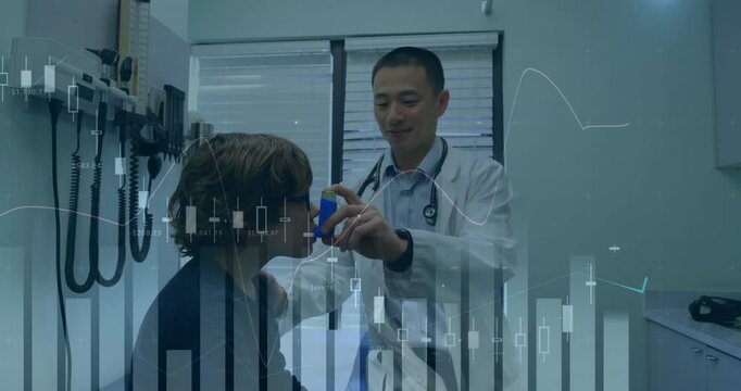 Male physician guiding child patient in clinic showing animated inhaler spacer and chart