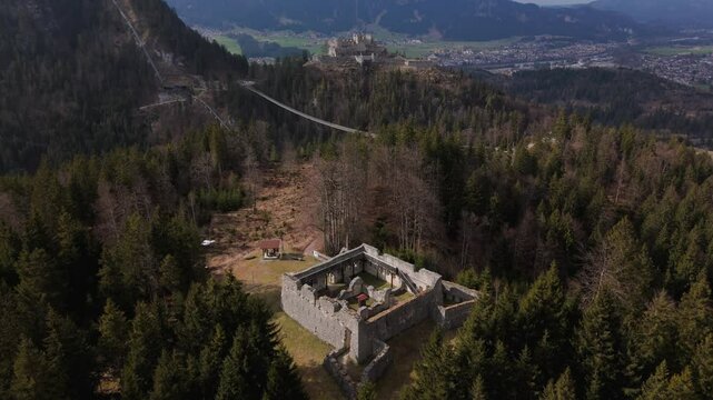 Drone footage of Fort Claudia in Tyrol, Austria, part of Ehrenberg fortification system. This high-angle view reveals ancient stone walls, mountain defense structures and Austrian Alps scenery. 