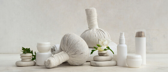 Composition with different cosmetic products, spa stones and clean towel on light background