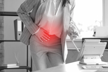 Young businesswoman with severe abdominal pain calling an ambulance in office, closeup